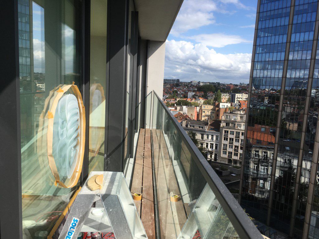 Terras op hoogte met een glazen balustrade en stadszicht erachter