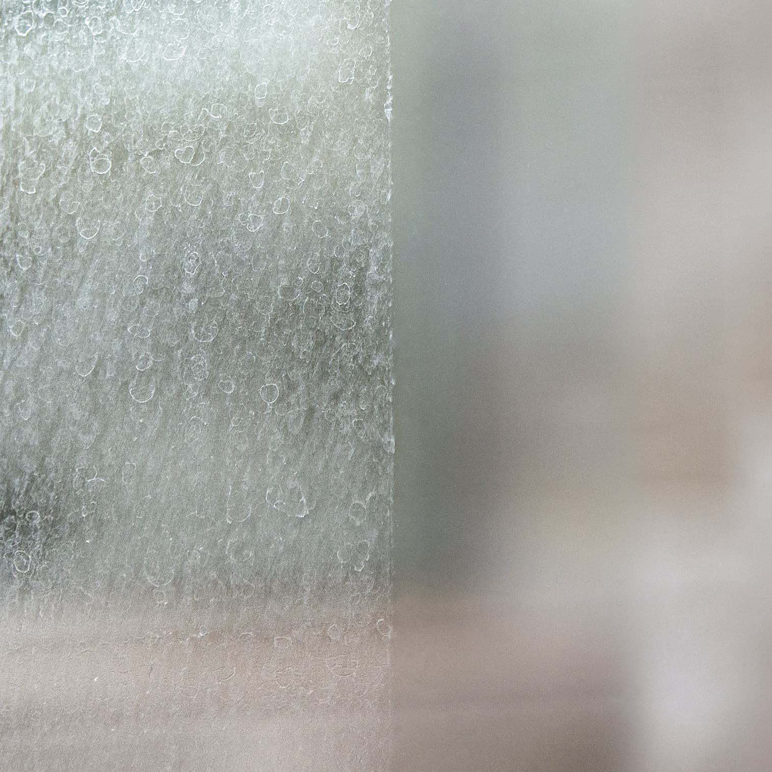 Eén ruit in twee helften: links zwaar ingevreten en dof, rechts helder, met de scheidingslijn door het midden
